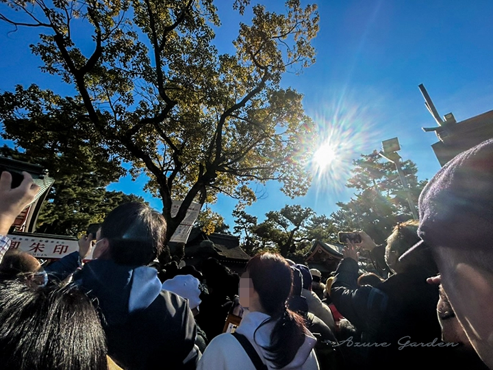 人々の間から見上げた、冬の空と強い陽射し。