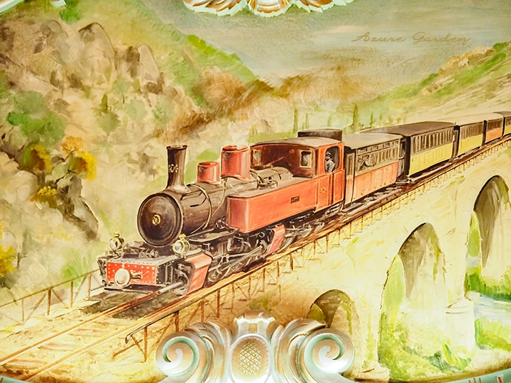 橋を渡る蒸気機関車が描かれた壁面装飾の風景画