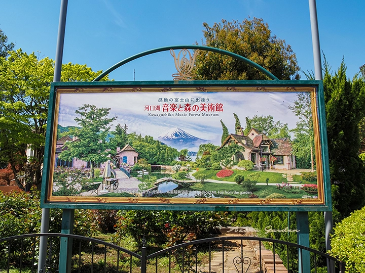 河口湖音楽と森の美術館の庭園と富士山が描かれた案内看板